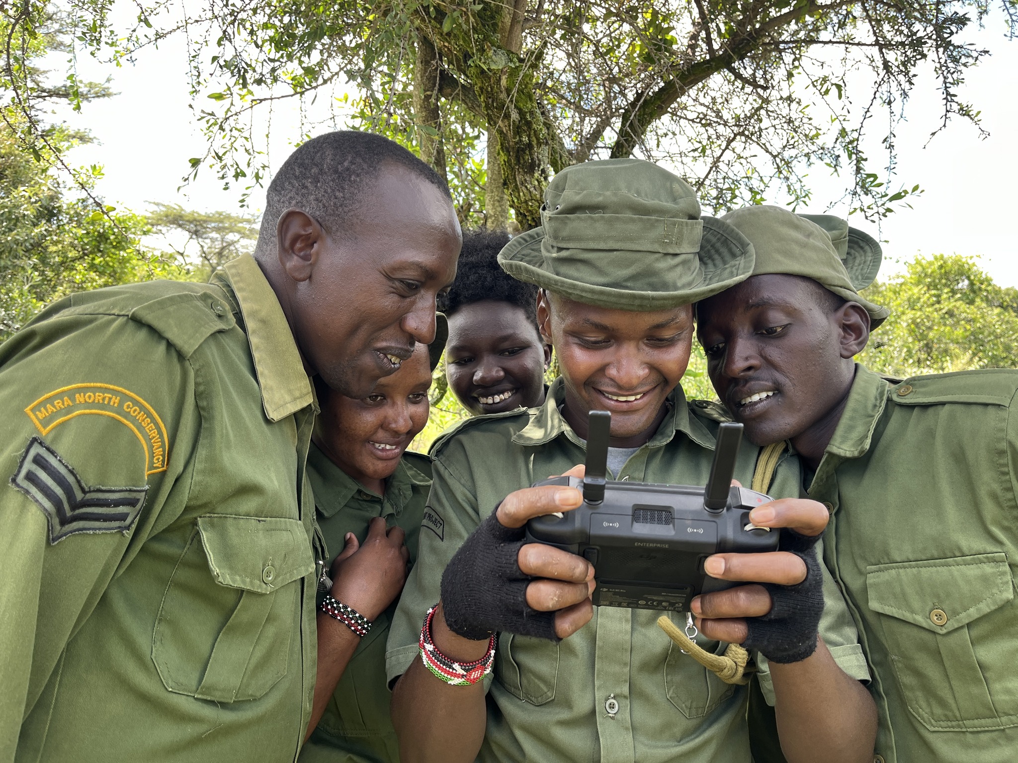 Conservancy rangers reviewing tracking equipment in the field